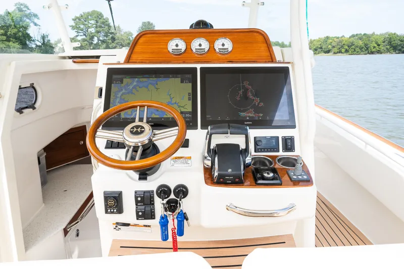 Slide: The Image of 2024 Hunt Yachts 32CC helm with advanced navigation and control systems on a serene water backdrop. - 21