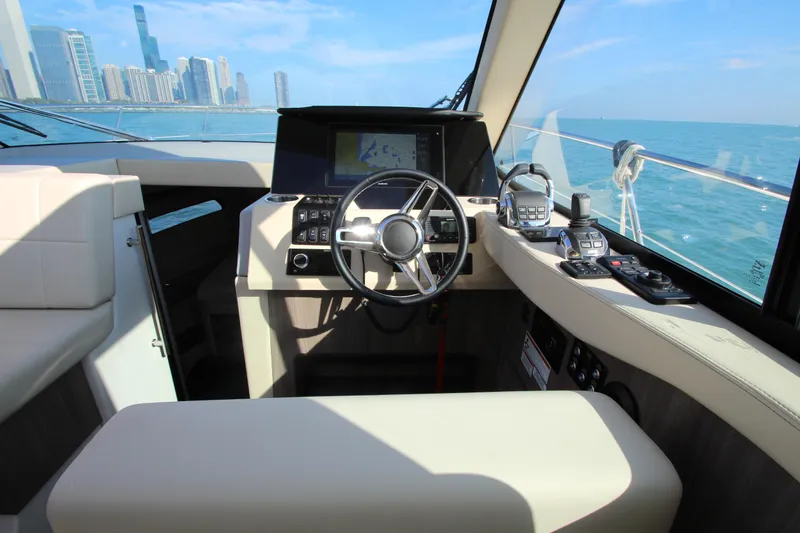 Slide: The Image of Das Cockpit der Regal 38 Grande Coupe 2021 mit modernem Steuer und Elektronik, vor einer Stadtlandschaft. - 17