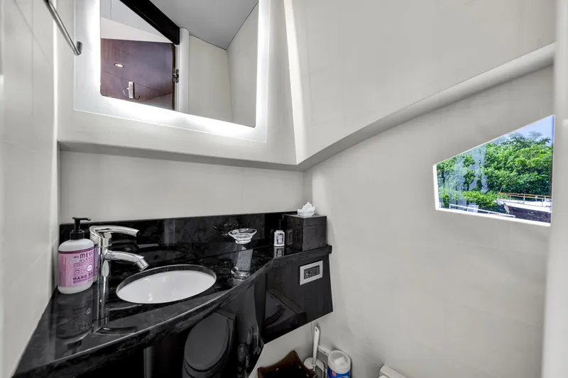 Slide: The Image of Luxuriöses Badezimmer mit schwarzer Arbeitsplatte, Waschbecken und Spiegel. Kleines Fenster mit Blick auf die Natur. - 9