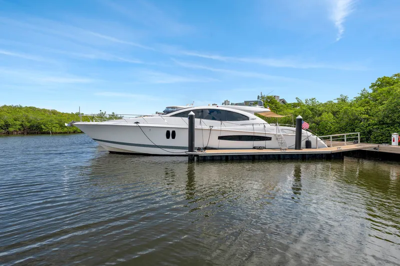 Slide: The Image of Eine elegante Lazzara LSX 75 Yacht von 2008 liegt an einem ruhigen Dock, umgeben von Bäumen. - 49