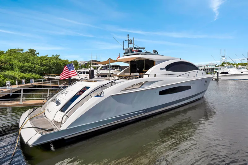 Slide: The Image of Eine elegante Lazzara LSX 75 Yacht von 2008 liegt im Wasser, umgeben von anderen Booten und grüner Vegetation. - 48
