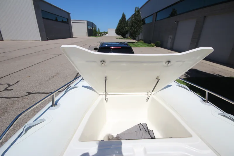 Slide: The Image of Open storage compartment on 2023 Zodiac Medline 7.5 boat, parked near industrial buildings. - 28