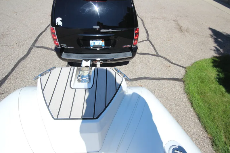 Slide: The Image of 2023 Zodiac Medline 7.5 boat hitched to a black SUV on a sunny day. - 30