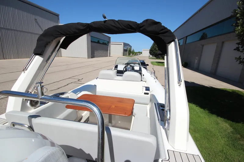 Slide: The Image of 2023 Zodiac Medline 7.5 boat with seating and table, parked near industrial buildings. - 8
