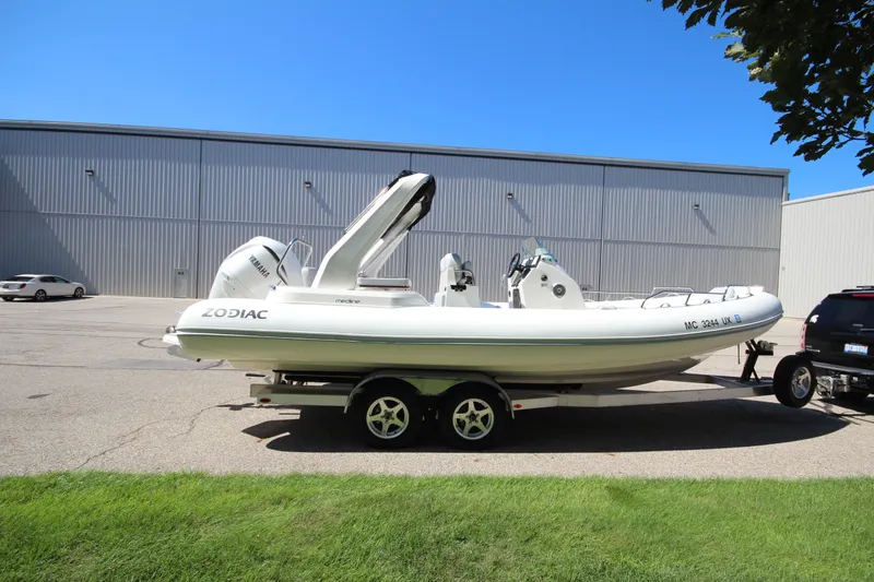 Slide: The Image of 2023 Zodiac Medline 7.5 boat on trailer, parked outdoors near a warehouse. - 4