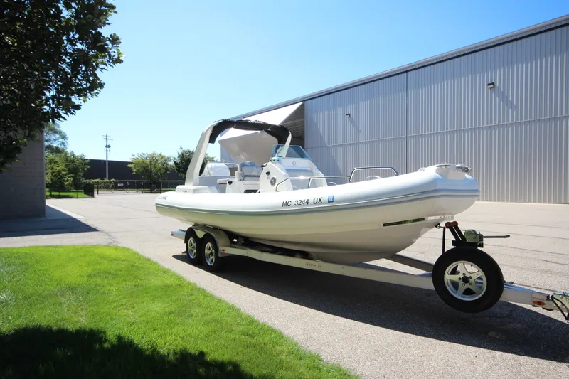 Slide: The Image of 2023 Zodiac Medline 7.5 boat on trailer, parked outdoors near a building. - 2