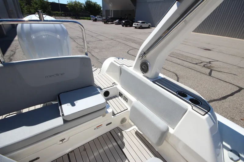 Slide: The Image of 2023 Zodiac Medline 7.5 boat interior with seating and cup holders in a parking area. - 13