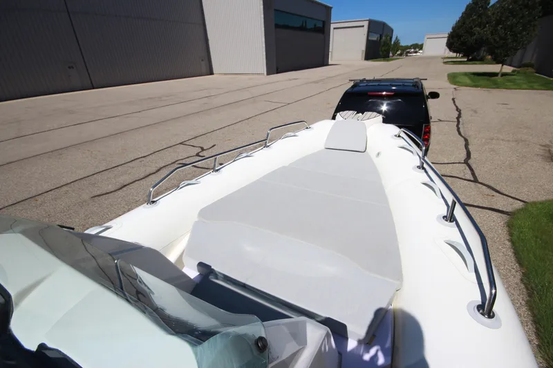 Slide: The Image of 2023 Zodiac Medline 7.5 boat on trailer, parked near industrial buildings. - 24