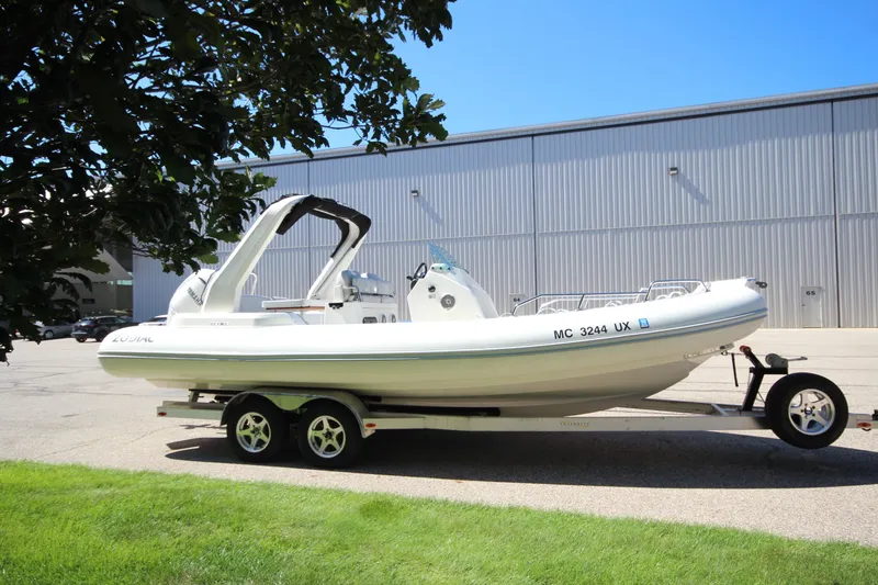 Slide: The Image of 2023 Zodiac Medline 7.5 boat on trailer, parked outdoors near a large building. - 3
