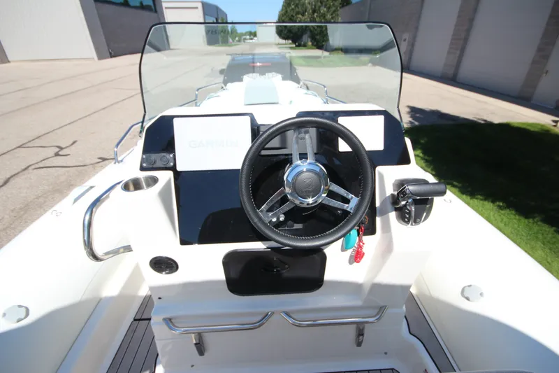 Slide: The Image of 2023 Zodiac Medline 7.5 boat dashboard with steering wheel and Garmin navigation system. - 20