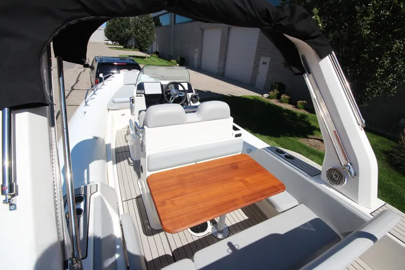 Slide: The Image of 2023 Zodiac Medline 7.5 boat interior with seating and wooden table. - 9