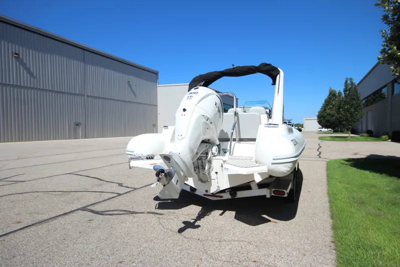 Slide: The Image of 2023 Zodiac Medline 7.5 boat on trailer, parked outdoors near industrial buildings. - 5