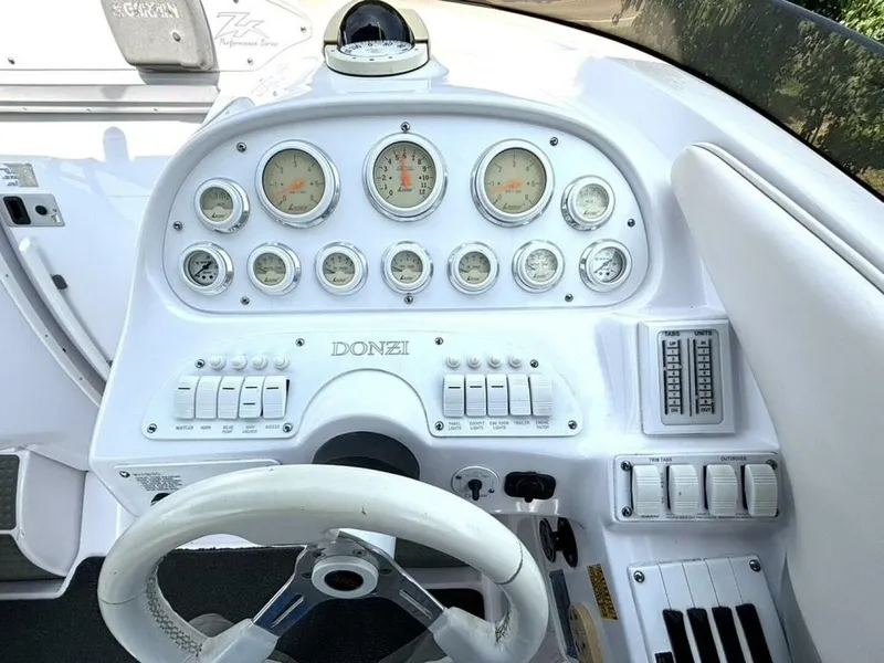 Slide: The Image of Dashboard of a 2005 Donzi 33 ZX with white gauges and steering wheel. - 24