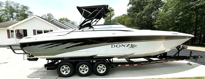 Slide: The Image of A 2005 Donzi 33 ZX on a trailer, parked in a driveway next to a house. - 6