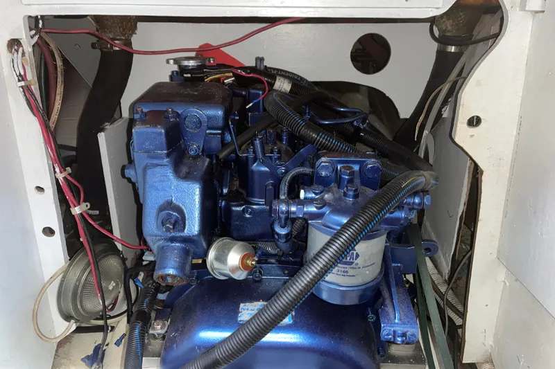 Slide: The Image of Engine compartment of a 1980 Cape Dory 30 sailboat, featuring a blue marine engine. - 32