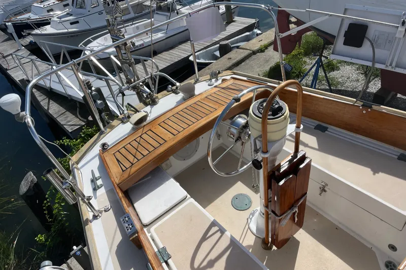 Slide: The Image of Cockpit of a 1980 Cape Dory 30 with wooden trim and steering wheel, docked in a marina. - 5