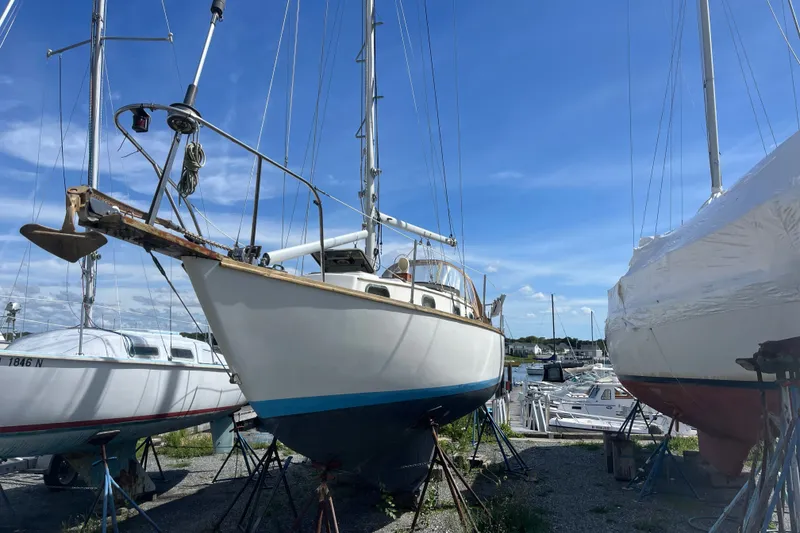 Slide: The Image of 1980 Cape Dory 30 sailboat on stands in a marina under a clear blue sky. - 1