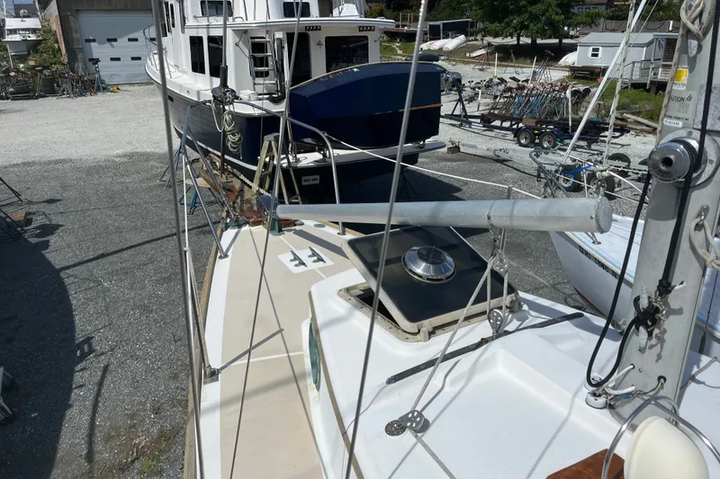 Slide: The Image of 1980 Cape Dory 30 sailboat on land, surrounded by other boats and equipment. - 12