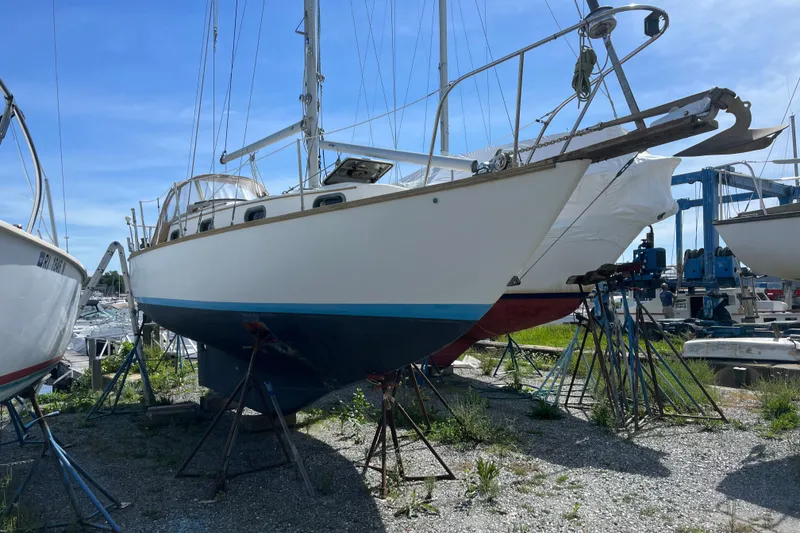 Slide: The Image of 1980 Cape Dory 30 sailboat on stands, ready for maintenance under a clear blue sky. - 2