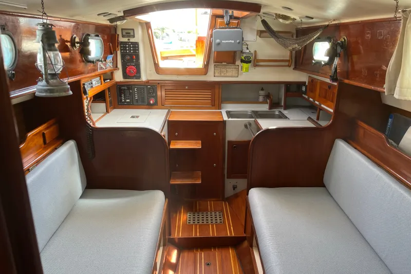 Slide: The Image of Interior of a 1980 Cape Dory 30 sailboat with wooden finishes and cozy seating. - 21