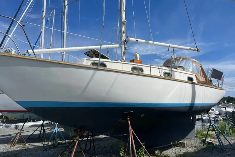 The Image of 1980 Cape Dory 30 sailboat on stands, blue sky background. - 0