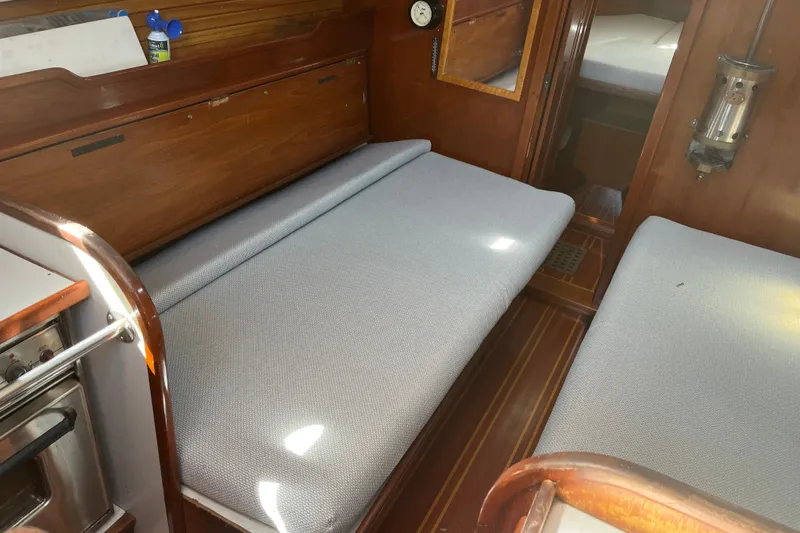 Slide: The Image of Interior of a 1980 Cape Dory 30 sailboat with cushioned seating and wooden finishes. - 28