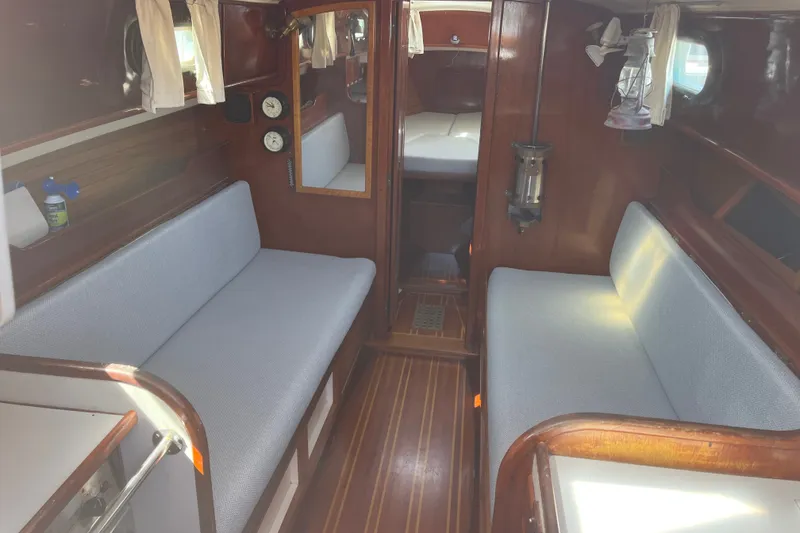Slide: The Image of Interior of a 1980 Cape Dory 30 sailboat with wooden finishes and cozy seating. - 16