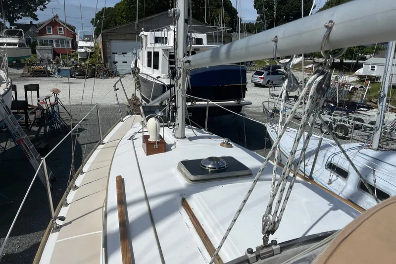 Slide: The Image of 1980 Cape Dory 30 sailboat on land, surrounded by other boats and equipment. - 11
