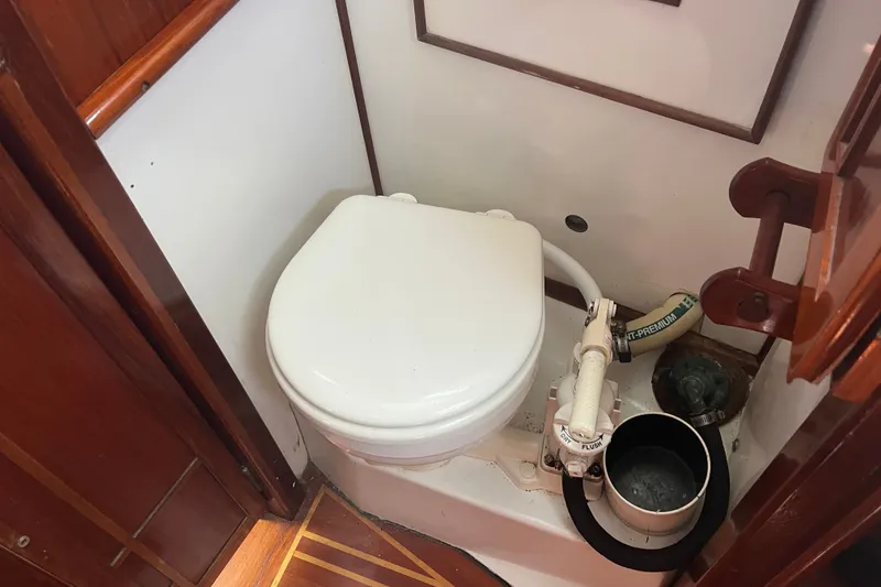 Slide: The Image of 1980 Cape Dory 30 boat bathroom with marine toilet and wooden accents. - 26