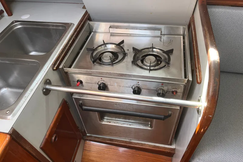 Slide: The Image of Compact kitchen area in a 1980 Cape Dory 30 sailboat with stove and sink. - 22