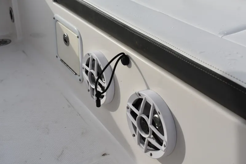 Slide: The Image of 2022 Robalo 246 Cayman boat interior with speakers and storage compartment. - 20
