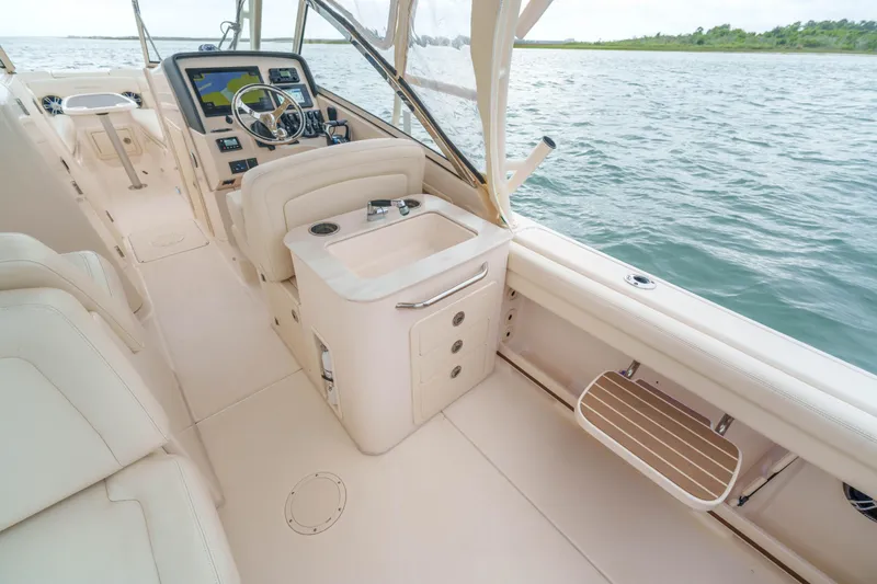 Slide: The Image of 2021 Grady-White Freedom 275 boat interior with helm, sink, and seating. - 9