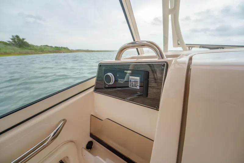 Slide: The Image of 2021 Grady-White Freedom 275 boat interior with Fusion audio system, near water. - 18