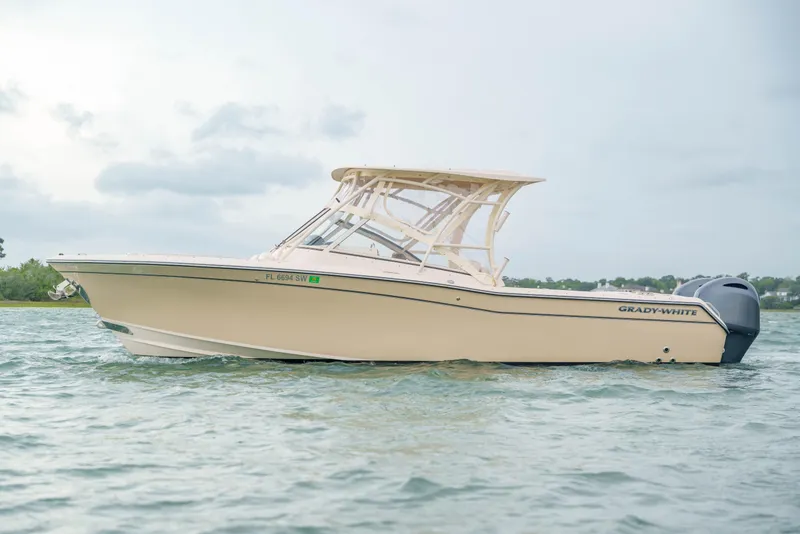 Slide: The Image of 2021 Grady-White Freedom 275 boat on water, showcasing sleek design and dual engines. - 4