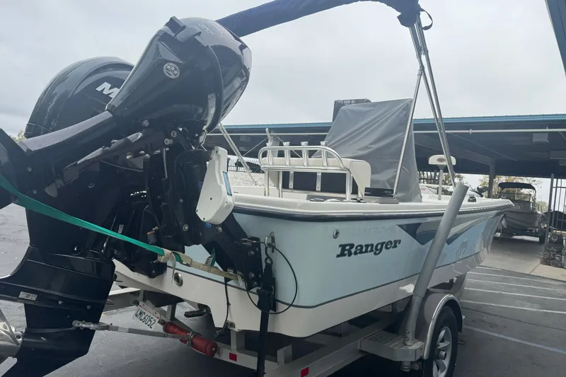 Slide: The Image of 2012 Ranger 220 Bahia boat on trailer with outboard motor in parking area. - 5
