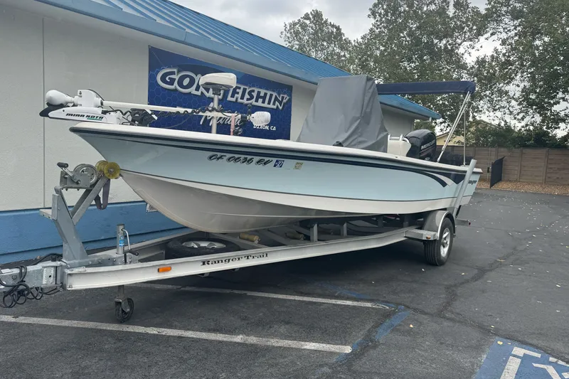 Slide: The Image of 2012 Ranger 220 Bahia boat on trailer, parked outside a fishing store. - 2