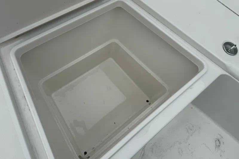 Slide: The Image of Storage compartment on a 2012 Ranger 220 Bahia boat, featuring a clean, white interior. - 13