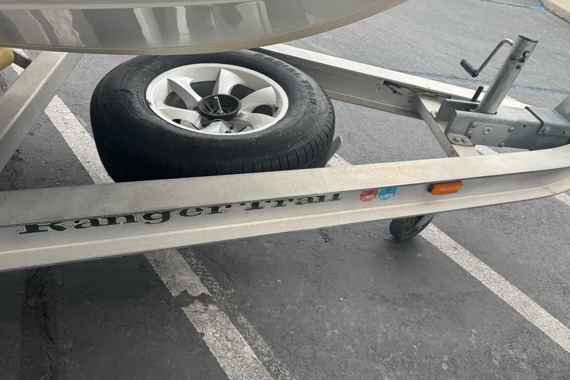 Slide: The Image of Trailer for 2012 Ranger 220 Bahia boat with spare tire in parking lot. - 4