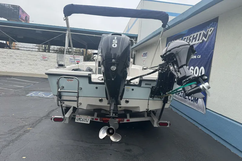 Slide: The Image of 2012 Ranger 220 Bahia boat with dual outboard motors in a parking lot. - 7