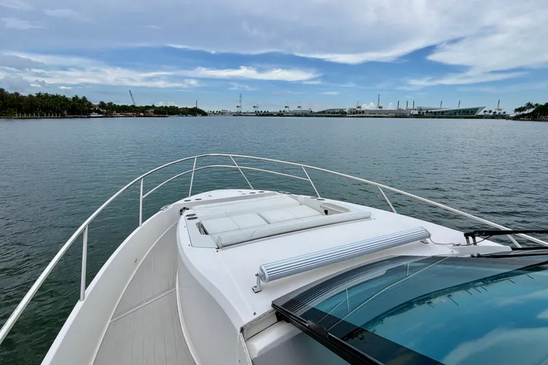 Slide: The Image of 2022 Regal 36 XO yacht cruising on calm waters under a partly cloudy sky. - 29