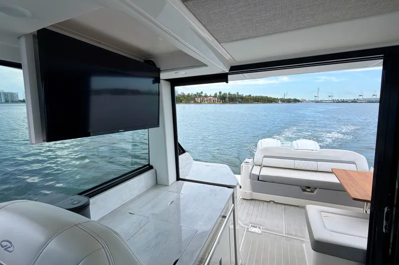 Slide: The Image of Interior view of 2022 Regal 36 XO yacht with TV and scenic water backdrop. - 25