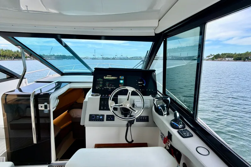 Slide: The Image of Interior view of 2022 Regal 36 XO yacht cockpit with modern controls and scenic water view. - 21