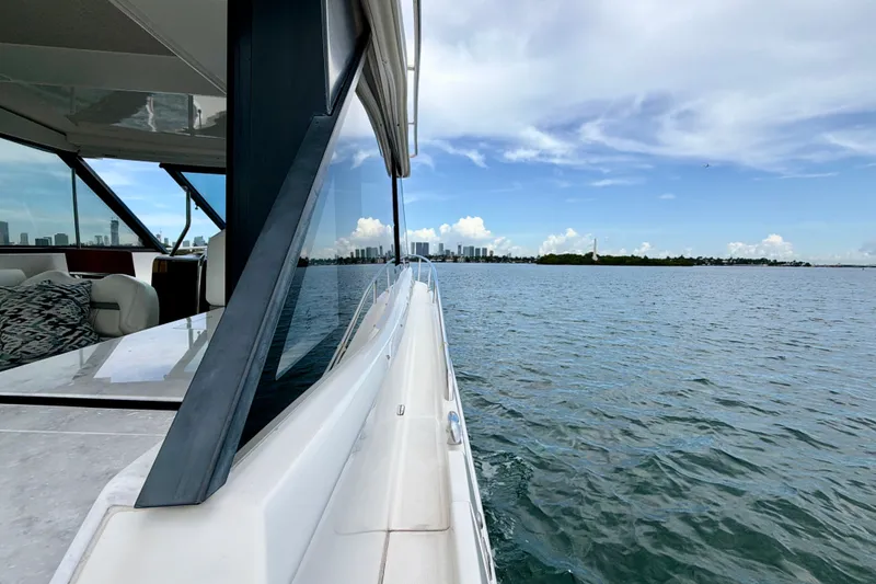 Slide: The Image of 2022 Regal 36 XO yacht cruising on a sunny day with city skyline view. - 27