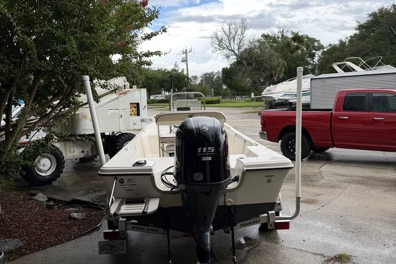 Slide: The Image of 2022 Carolina Skiff 178 CC boat with Yamaha 115 engine, parked near red truck. - 3