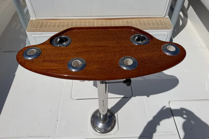 Slide: The Image of Wooden table with metal cup holders on a 2019 Regulator 41 boat deck. - 45