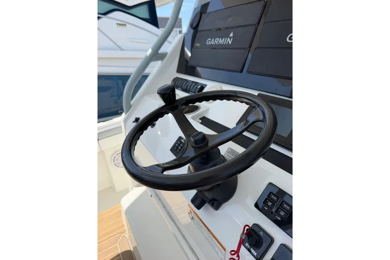Slide: The Image of Steering wheel and controls of a 2019 Regulator 41 boat with Garmin displays. - 33