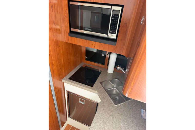 Slide: The Image of Compact kitchen area in a 2019 Regulator 41 boat with microwave and sink. - 47