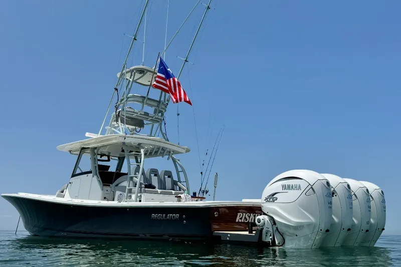 The Image of 2019 Regulator 41 boat with Yamaha engines and American flag on calm water. - 0