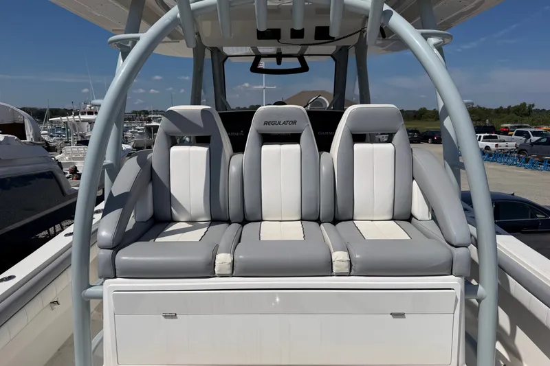 Slide: The Image of 2019 Regulator 41 boat seating with gray and white upholstery at a marina. - 34