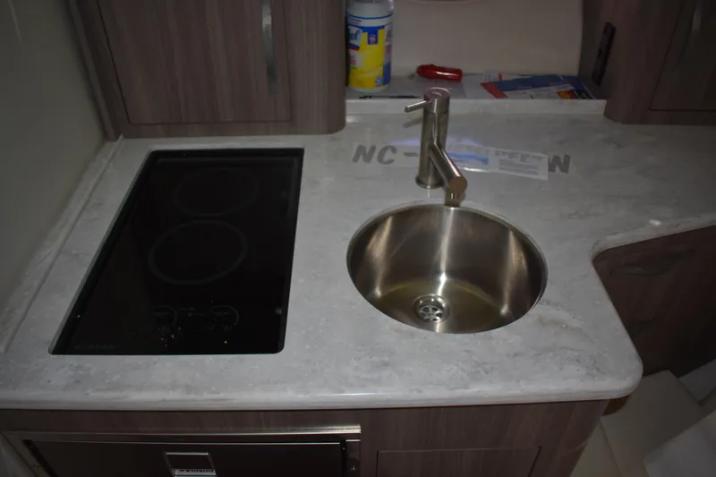 Slide: The Image of Modern kitchen area in 2020 Regal 35 Sport Coupe with sink and stovetop. - 22